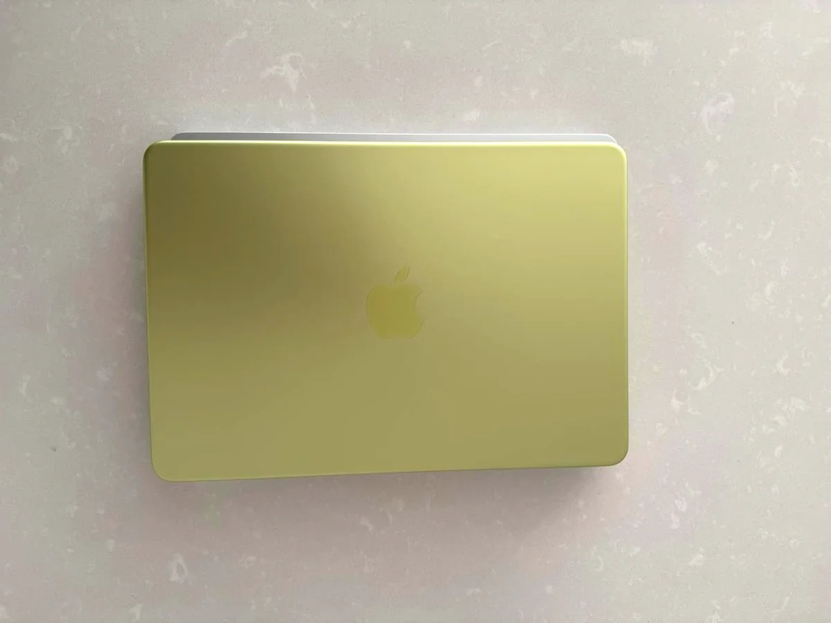 MacBook Neo Touch ID setup screen with finger on the power button sensor, citrus keyboard visible
